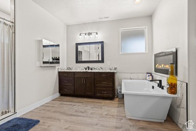 711 W Main St, Enterprise, UT 84725 - bathroom with vanity, hardwood / wood-style flooring, independent shower and bath, and a textured ceiling