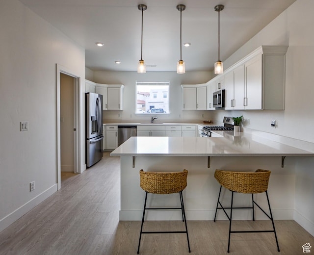 651 W Owen Dr, St George, UT 84790 - kitchen with kitchen peninsula, stainless steel appliances, white cabinetry, and a breakfast bar area