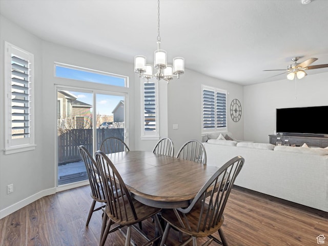 dining space featuring ceiling fan with notable chandelier and dark hardwood / wood-style floors