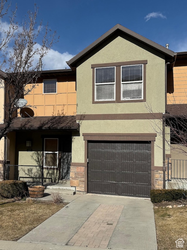 view of front facade featuring an attached garage, a porch, stucco siding, stone siding, and driveway
