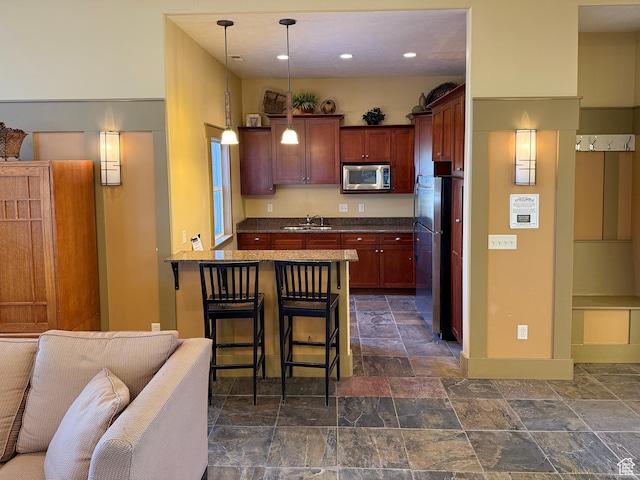 127 E Chandlerpoint Way S, Draper, UT 84020 - kitchen with a peninsula, a sink, stainless steel appliances, stone finish floor, and dark countertops