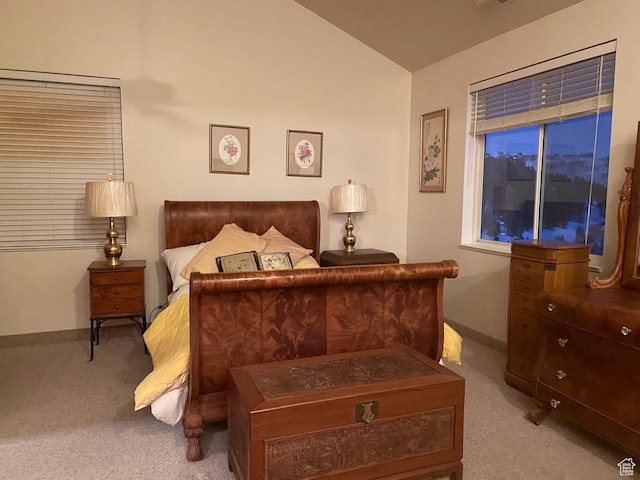 bedroom featuring lofted ceiling and light carpet