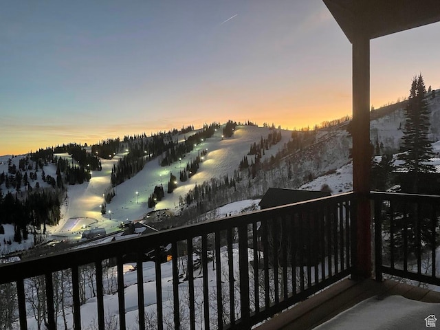 snow covered back of property featuring a mountain view