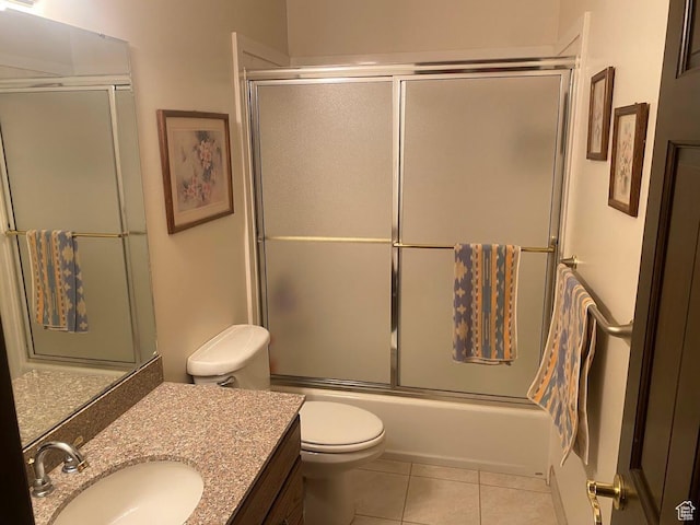full bathroom featuring tile patterned flooring, vanity, toilet, and combined bath / shower with glass door