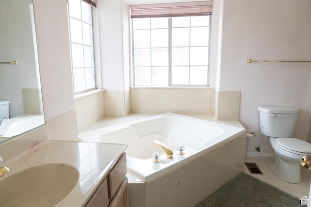 bathroom featuring a washtub, vanity, and toilet