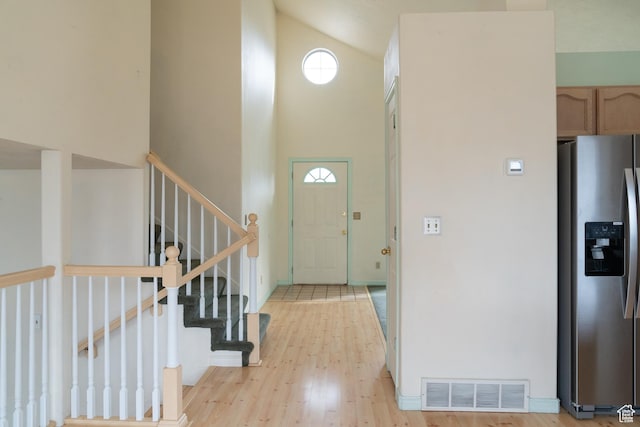 foyer entrance with a high ceiling and light wood-type flooring