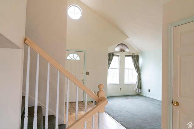 staircase with high vaulted ceiling and carpet