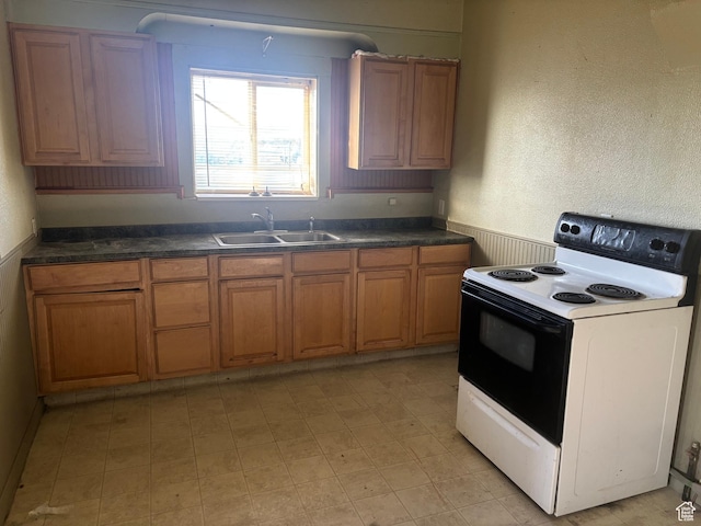 105 W 400 N, Centerfield, UT 84622 - kitchen featuring electric stove, a sink, brown cabinets, wainscoting, and dark countertops