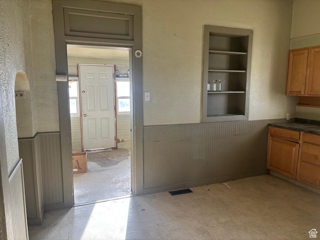 105 W 400 N, Centerfield, UT 84622 - kitchen featuring wainscoting, light floors, dark countertops, built in shelves, and wooden walls