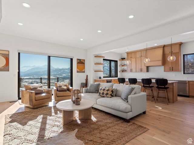 living area featuring a mountain view, light wood-style floors, and recessed lighting