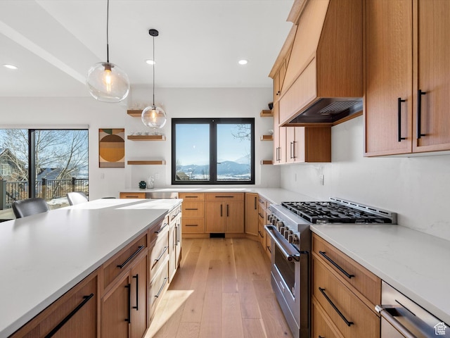 kitchen with open shelves, light wood-type flooring, high end stainless steel range, decorative light fixtures, and light countertops