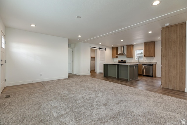 442 W Pipe Springs Dr, Kanab, UT 84741 - kitchen featuring appliances with stainless steel finishes, dark carpet, a kitchen island, a barn door, and wall chimney range hood