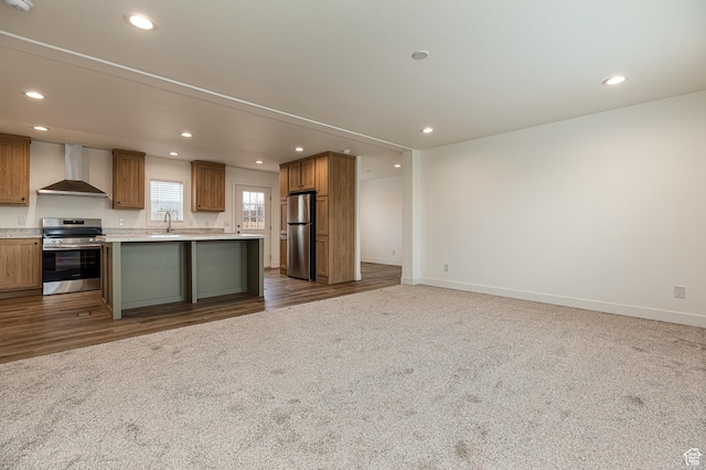 442 W Pipe Springs Dr, Kanab, UT 84741 - kitchen featuring wall chimney exhaust hood, appliances with stainless steel finishes, an island with sink, and dark colored carpet
