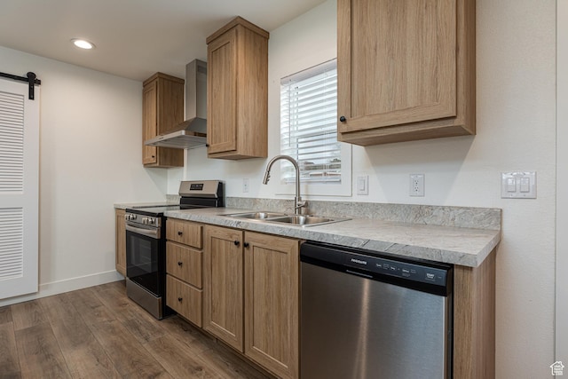 442 W Pipe Springs Dr, Kanab, UT 84741 - kitchen featuring wall chimney exhaust hood, sink, appliances with stainless steel finishes, a barn door, and hardwood / wood-style floors