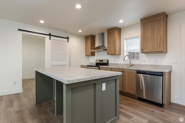 442 W Pipe Springs Dr, Kanab, UT 84741 - kitchen featuring a kitchen island, sink, stainless steel appliances, a barn door, and wall chimney exhaust hood