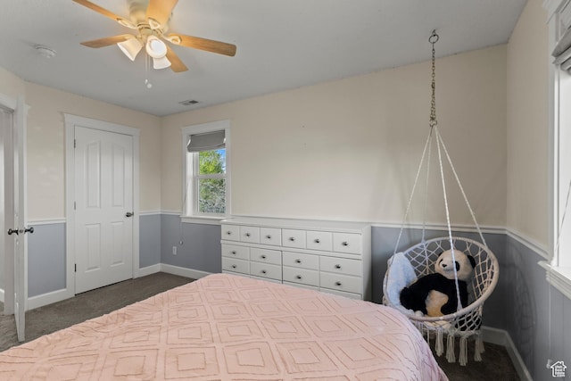 bedroom with ceiling fan, dark colored carpet, baseboards, and visible vents