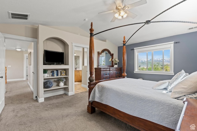 bedroom with carpet, baseboards, ensuite bath, visible vents, and vaulted ceiling