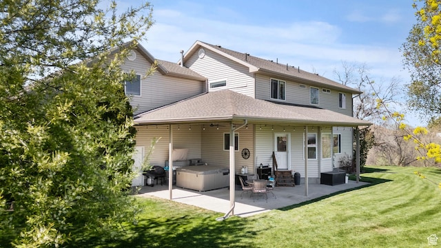 rear view of property featuring entry steps, a patio, a shingled roof, and a lawn