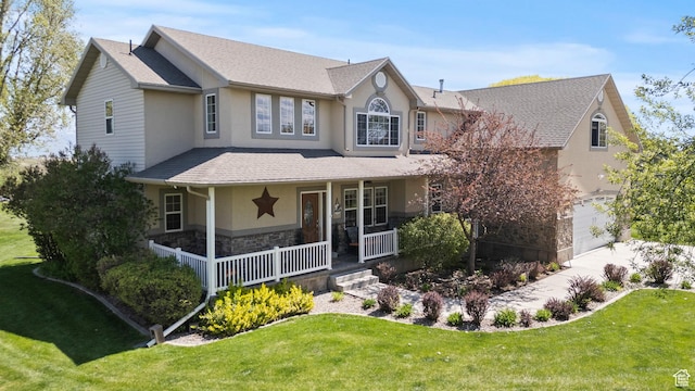 traditional-style house with covered porch, stucco siding, a front yard, and stone siding
