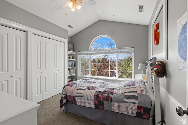carpeted bedroom with lofted ceiling, ceiling fan, multiple closets, and visible vents