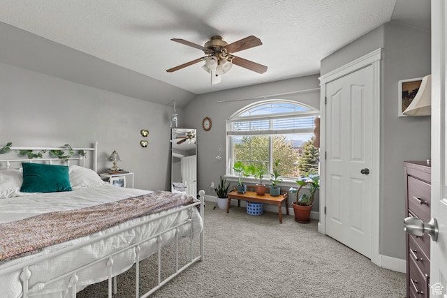 carpeted bedroom featuring vaulted ceiling, baseboards, and a ceiling fan