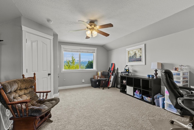 office area with a textured ceiling, vaulted ceiling, ceiling fan, carpet flooring, and baseboards