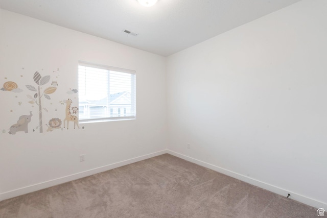 unfurnished room featuring visible vents, carpet, and baseboards