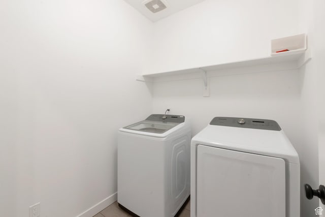 laundry room with visible vents, washing machine and clothes dryer, laundry area, and baseboards