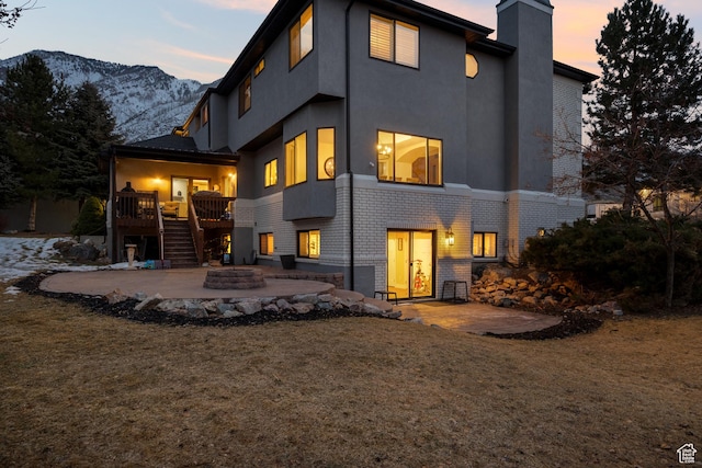 1533 Rosanna Ln, Alpine, UT 84004 - back house at dusk with an outdoor fire pit, a patio, and a lawn