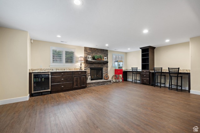 1533 Rosanna Ln, Alpine, UT 84004 - living room featuring wine cooler, a stone fireplace, and dark wood-type flooring