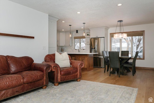 1453 E 1200 N, Logan, UT 84341 - living area featuring light wood-type flooring, recessed lighting, healthy amount of natural light, baseboards, and a textured ceiling