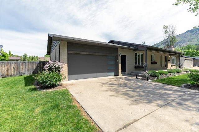 1453 E 1200 N, Logan, UT 84341 - view of front of home with brick siding, a garage, driveway, and a mountain view
