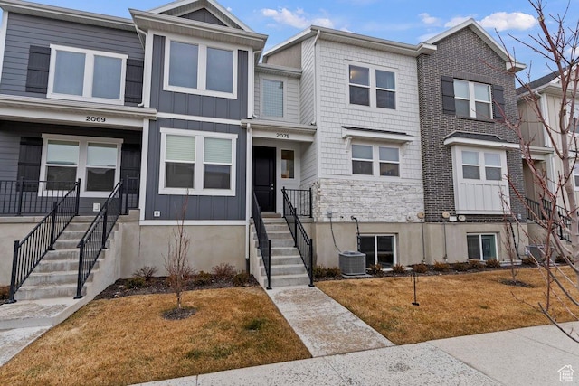 townhome / multi-family property featuring central AC and a front lawn