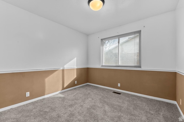 empty room with visible vents, baseboards, and carpet floors