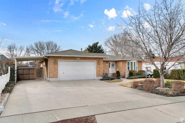 ranch-style house with brick siding, driveway, an attached garage, and fence
