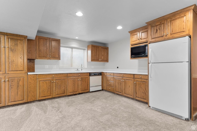 kitchen featuring light countertops, recessed lighting, brown cabinets, white appliances, and a sink