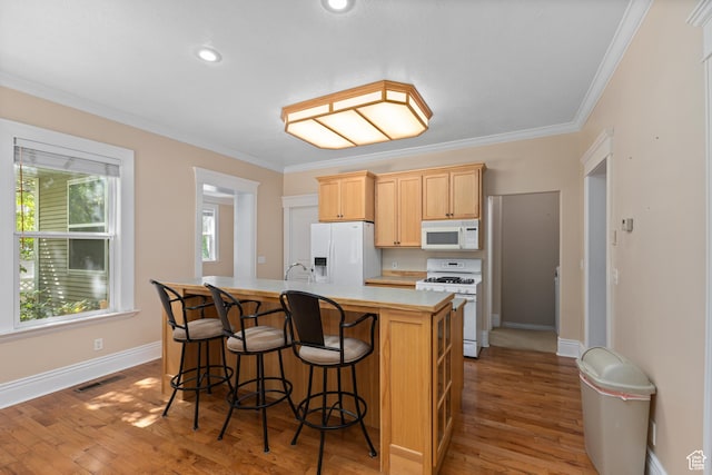 291 N Main St, Hyde Park, UT 84318 - kitchen with light brown cabinetry, an island with sink, light hardwood / wood-style floors, crown molding, and white appliances