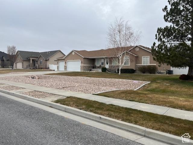 334 S Lariat Way, Grantsville, UT 84029 - ranch-style home with a garage, a residential view, driveway, and stucco siding
