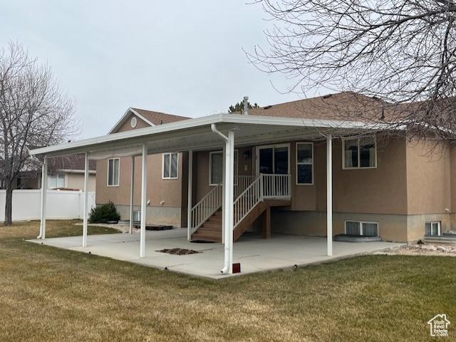 334 S Lariat Way, Grantsville, UT 84029 - back of property with fence, a lawn, and stucco siding
