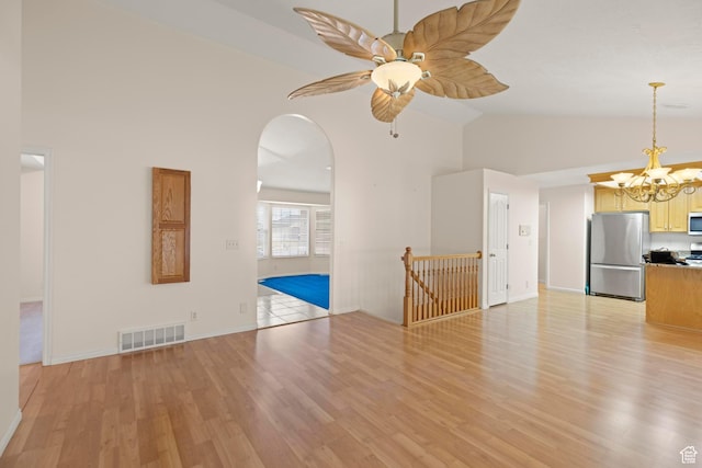 334 S Lariat Way, Grantsville, UT 84029 - unfurnished living room featuring arched walkways, visible vents, light wood finished floors, and high vaulted ceiling