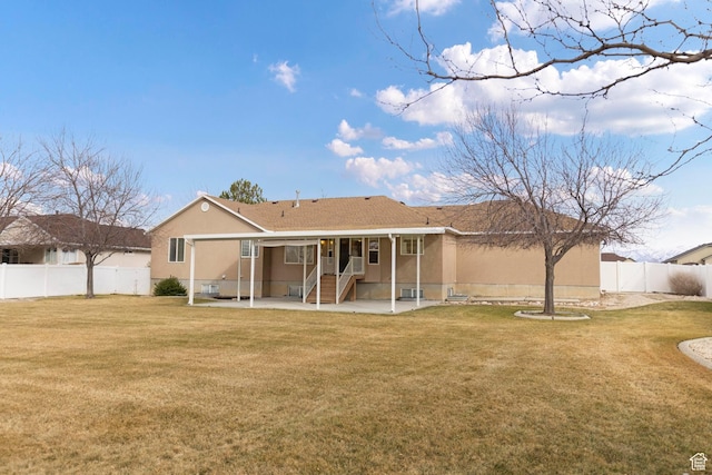 334 S Lariat Way, Grantsville, UT 84029 - rear view of house with a fenced backyard, stucco siding, a patio area, and a lawn