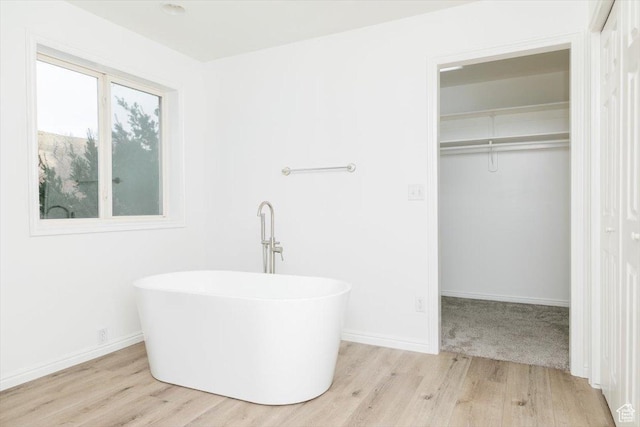 bathroom with a washtub and hardwood / wood-style flooring