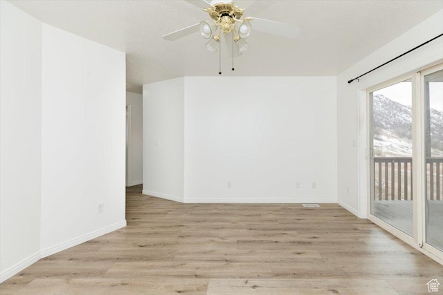empty room featuring ceiling fan and light hardwood / wood-style floors