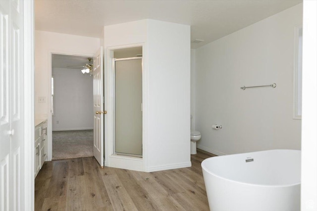 full bathroom with hardwood / wood-style flooring, vanity, toilet, and separate shower and tub