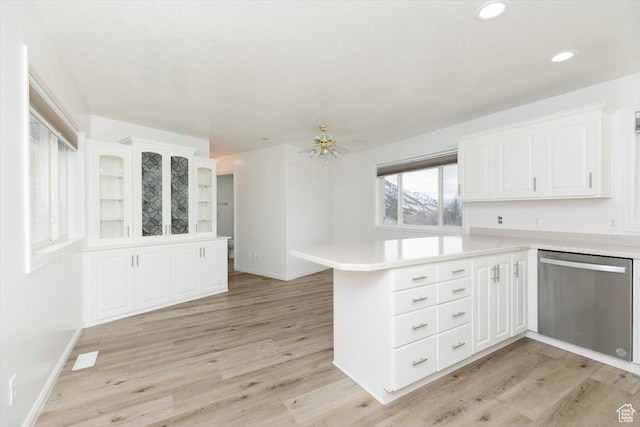 kitchen featuring dishwasher, kitchen peninsula, white cabinets, and light hardwood / wood-style flooring