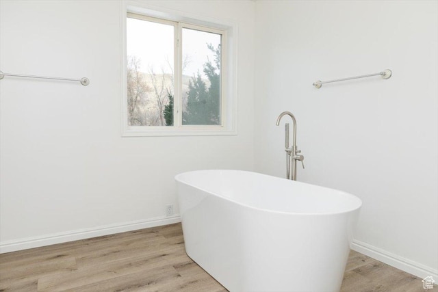bathroom with wood-type flooring and a bathtub