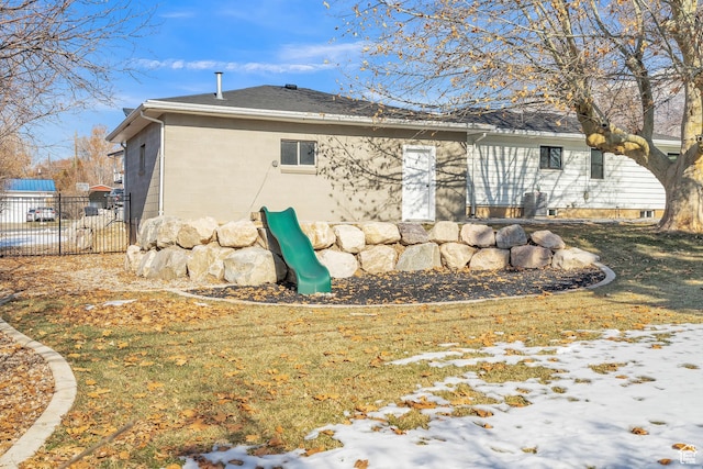 rear view of property featuring a lawn and a playground