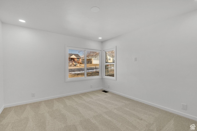 spare room featuring light carpet