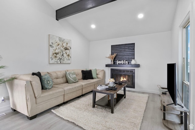 living room featuring vaulted ceiling with beams and light hardwood / wood-style floors