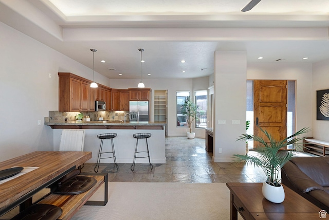 2085 N Tuweap Unit 52, St George, UT 84770 - kitchen with a breakfast bar, pendant lighting, tasteful backsplash, kitchen peninsula, and stainless steel appliances